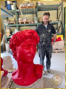 在马里内利铸造厂精心包装之前，一位工匠站在米开朗基罗的大卫无瑕疵的红色蜡像旁边